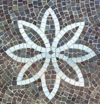 Paving with cobble stones and flower shaped design made with cubes of marble.