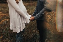 pregnant couple holding hands 