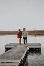 couple on a dock holding hands 