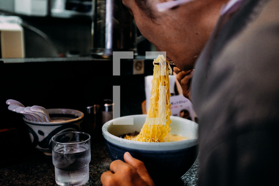 man eating noodles in a restaurant in Japan 