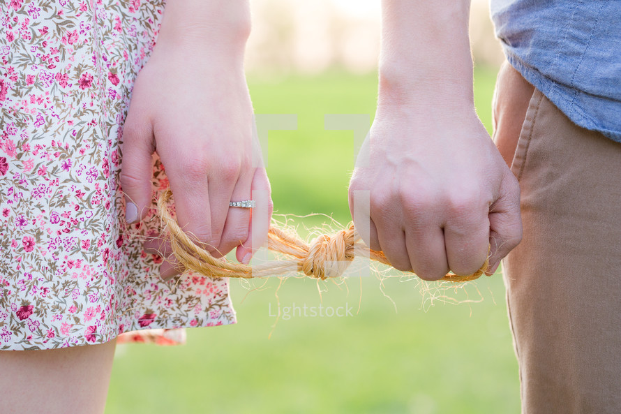engaged couple holding a knot 