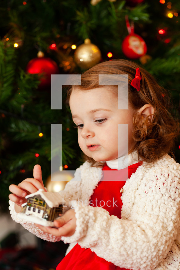 child near Christmas tree.