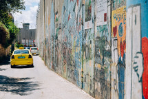 taxi cabs and graffiti covered wall 