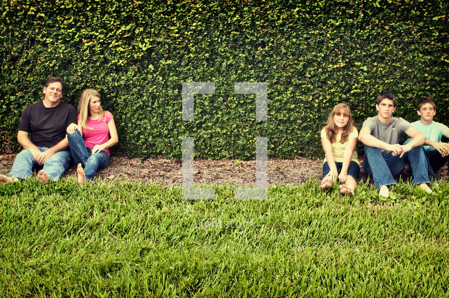 Family sitting in front of wall