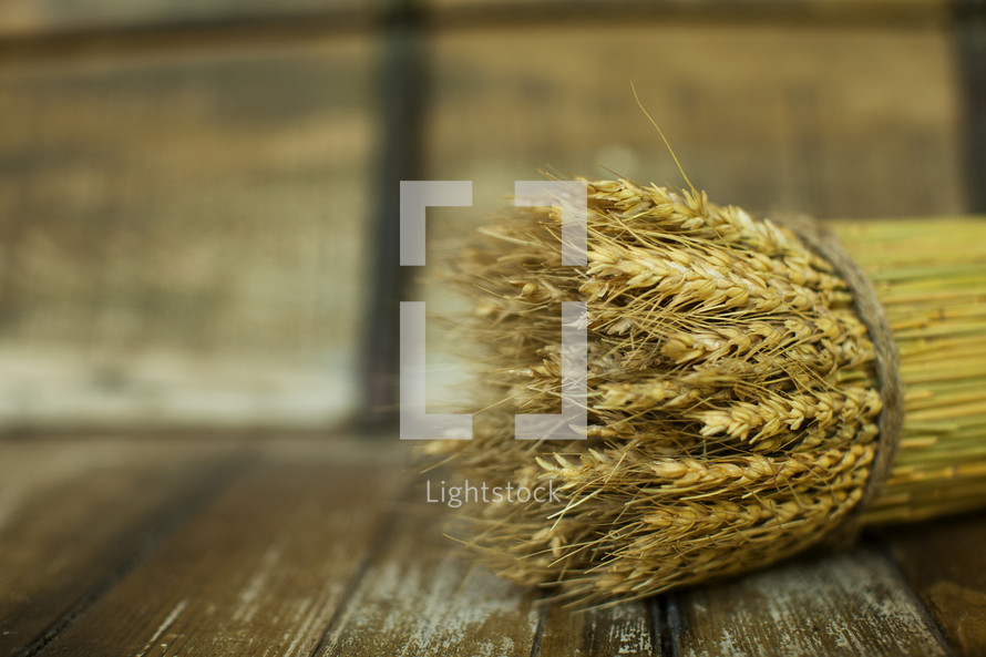 Bushel of wheat sitting on a wood table
