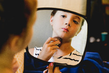 a teen girl putting on make up 
