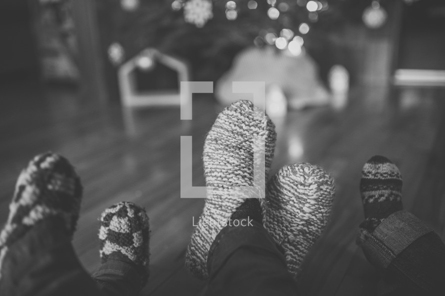 feet in cozy socks in front of a Christmas tree 