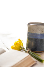 a cup of coffee with a Bible and flowers