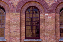 reflection in the glass of a window on a brick building 