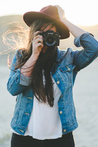 A young woman taking a picture with a camera.