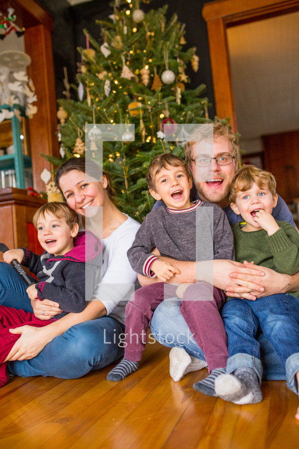family in front of a  Christmas tree 