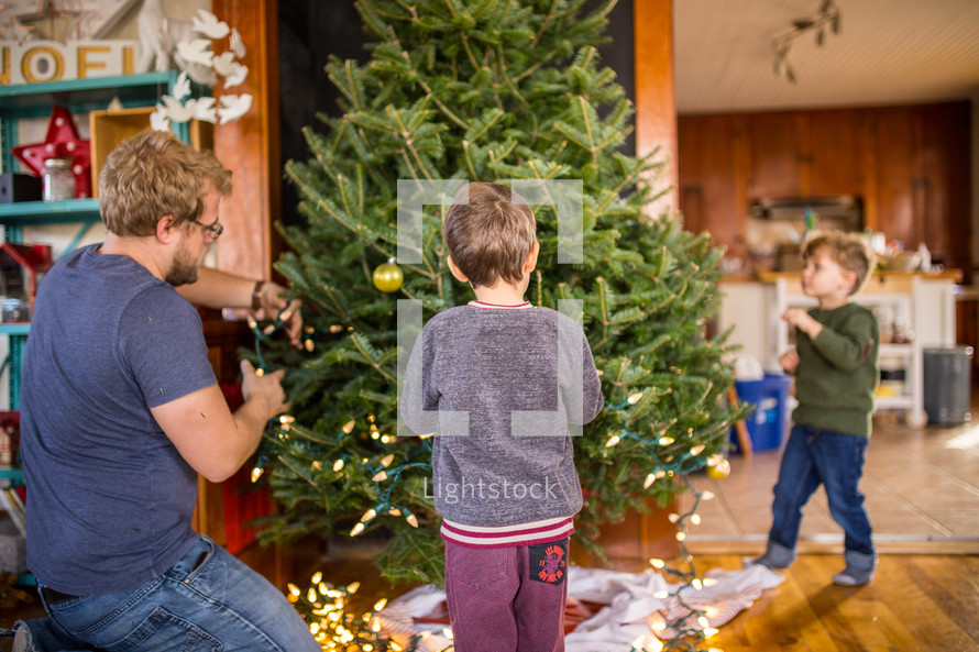 father and son's decorating a Christmas tree 