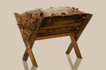 Swaddling clothes in a wooden manger filled with hay.