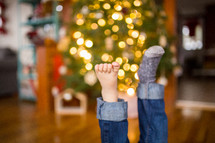 feet in socks in front of a Christmas tree 