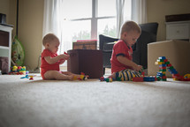 toddler boys playing with building blocks 