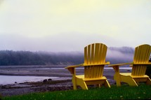 Adirondack chairs on a shore 