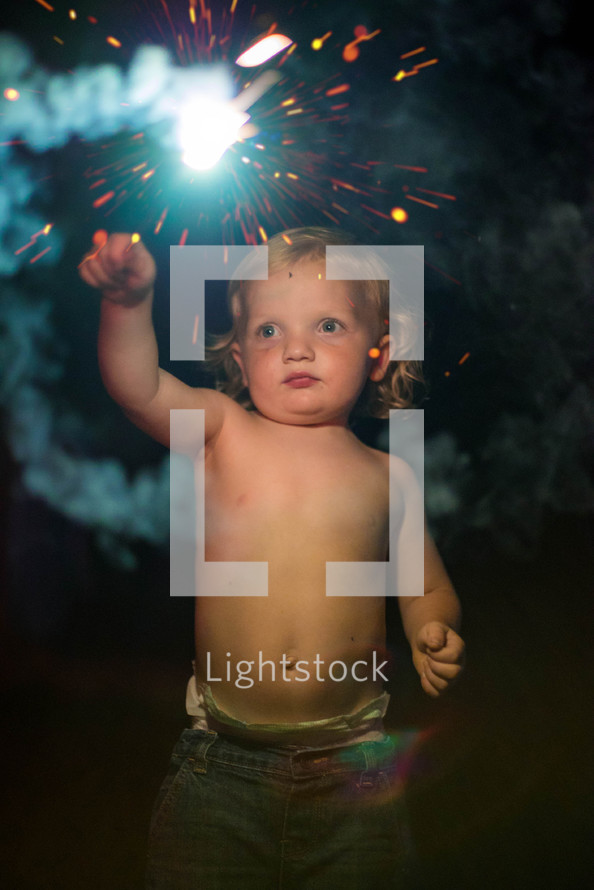 toddler holding a sparkler firework 