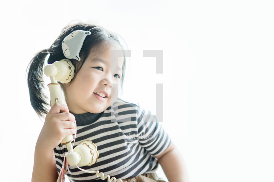 little girl talking on an antique phone 