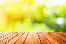 wooden deck and out of focus green plants 