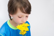 Boy smelling flowers.