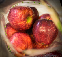 A bag of fresh red apples.