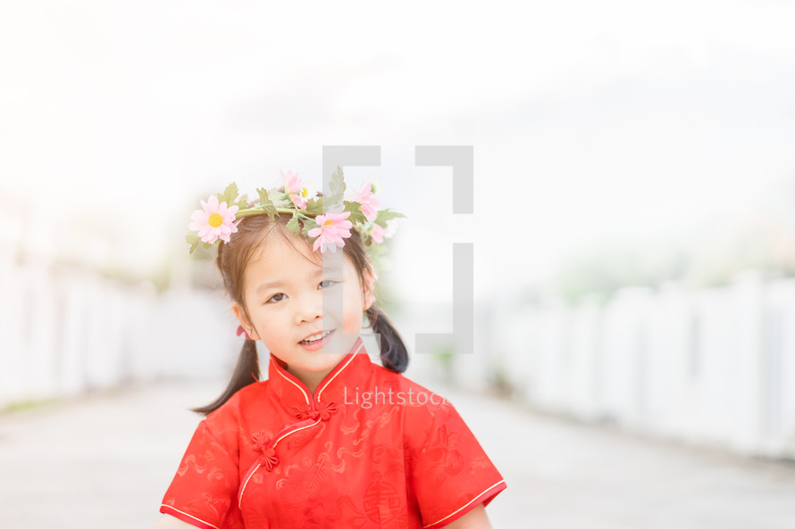 a little girl in a red traditional Chinese dress 
