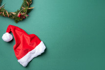 Red Santa Clause hat and a wreath with copy space
