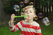 a boy blowing bubbles 