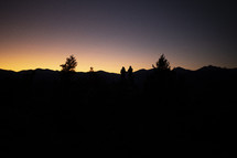 silhouettes of people and Mountains at dusk 