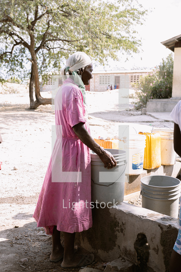 a woman gathering clean water in a village 