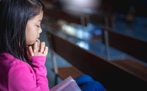 praying child alone in a church 
