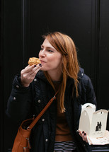 a woman taking a bite out of a muffin 