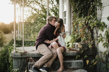man kissing a woman on a porch