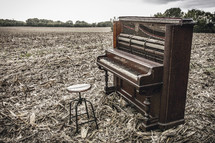old piano in a plowed field 