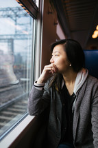 a woman looking out the window of a train 