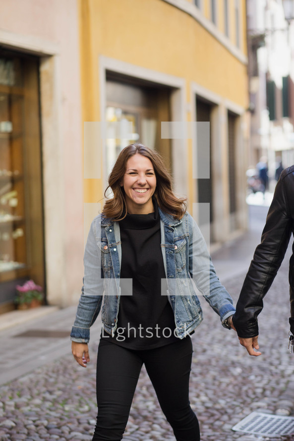 woman walking on a cobblestone street 