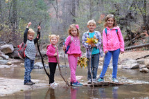 kids standing together outdoors in a stream 