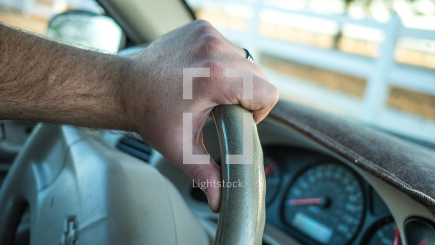 hand on a steering wheel 
