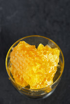 Honeycomb and honey on black ardesia plate