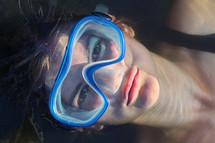 a woman floating in a pool wearing goggles 