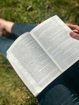 reading a Bible in the grass
