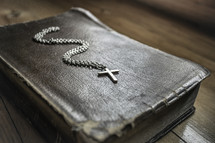 cross necklace on the cover of a Bible 