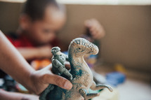 child playing with a dinosaur toy 