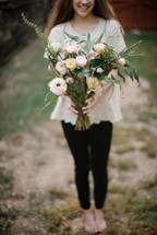 a teen girl holding a bouquet of flowers 