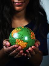 a girl holding a globe 