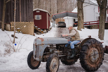an elderly man on a tractor in winter 