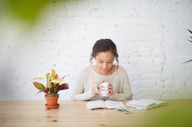 woman sitting at a desk reading a Bible 
