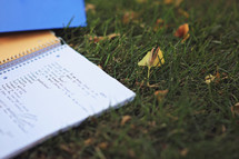 words on a notebook lying in the grass 