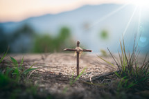 cross in the ground and mountains in the background 