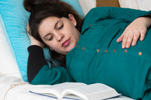 a pregnant woman reading scripture 